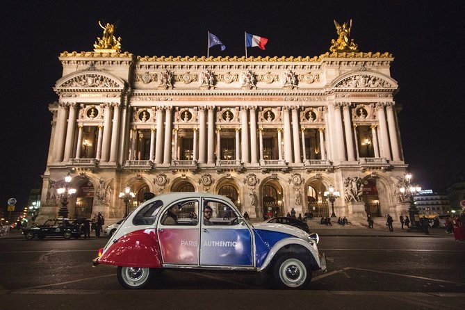 A vintage Citro&euml;n 2CV parked outside the floodlit Palais Garnier