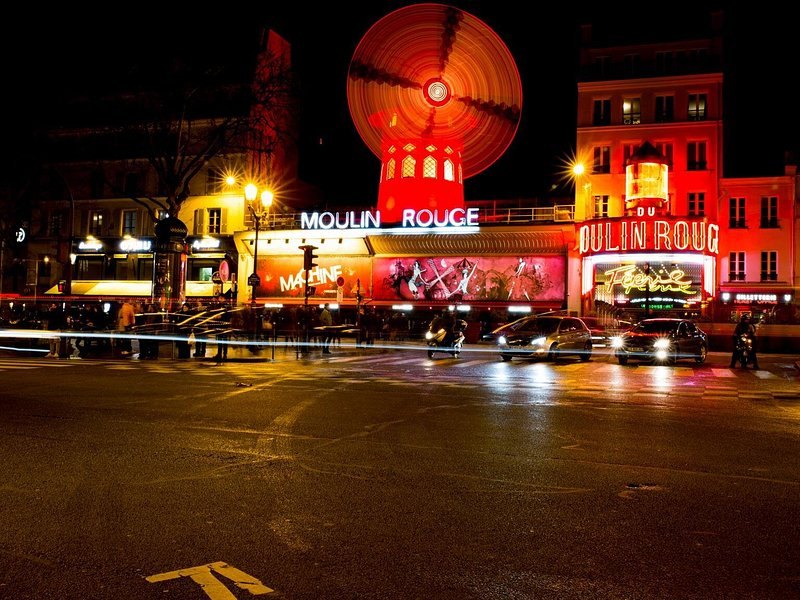 The red windmill of the Moulin Rouge lit on the Boulevard de Clichy