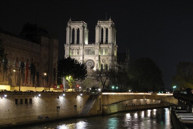 Notre-Dame seen across the Seine at night with the quays lit below