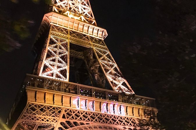 The Eiffel Tower mid-sparkle, its 20,000 bulbs firing against a black sky