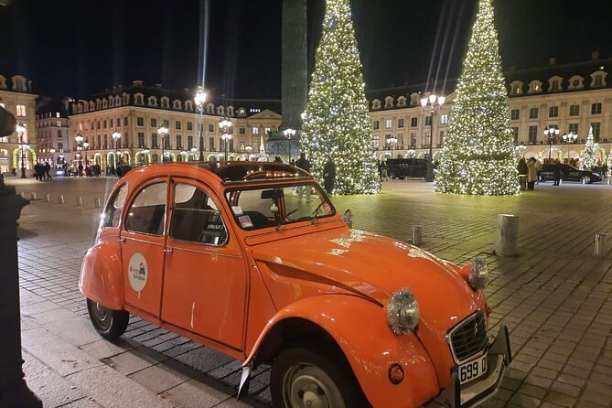 Lit Christmas trees ringing Place Vend&ocirc;me with a vintage Citro&euml;n 2CV in front