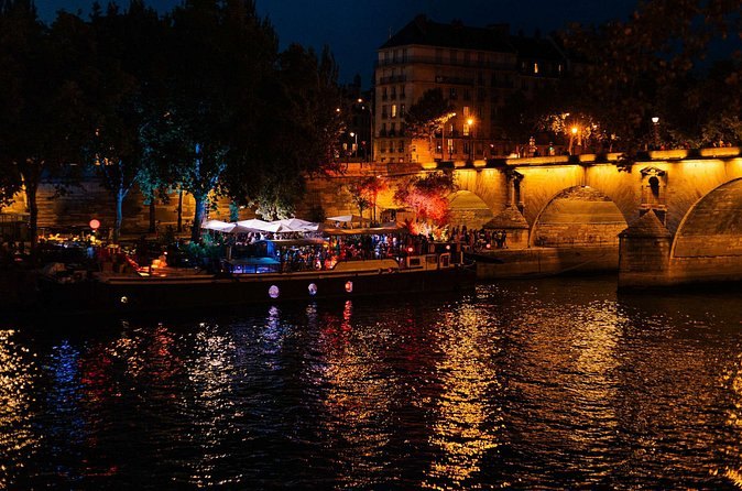 Lamps along the Seine quays reflected in the water after dark